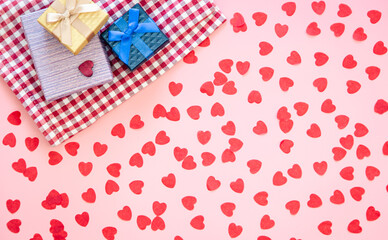 Gift boxes and pink background with small hearts, flat lay.