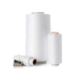 Thread spools and thimble isolated on white background