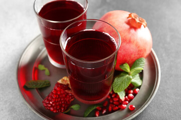 Plate with fresh pomegranate juice on table, closeup