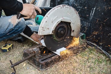 Man doing metal work using hand cutting machine tool	