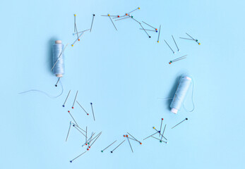 Frame made of thread spools and ball pins on color background