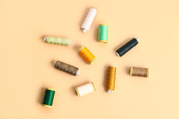 Set of different thread spools on color background