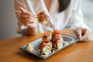 hand hold unagi sushi roll on chopstick