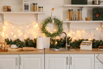 Interior of kitchen with Christmas wreath, counters and shelves