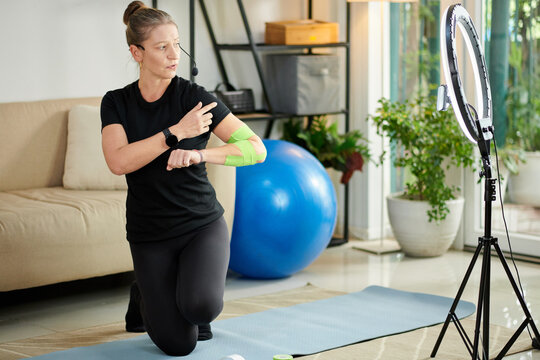 Fitness Blogger Applying Kinesiology Tape - Powered by Adobe