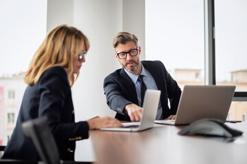 Group of business people having meeting at the boardroom. Businessman and business woman working on a laptop. Teamwork at the office.