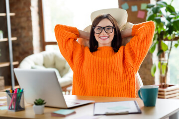 Photo of smart positive person sitting chair hands behind head complete marketing project task...