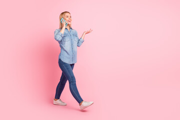 Full length photo of cheerful positive girl laughing at joke by friend walk talk cellphone isolated pastel color background