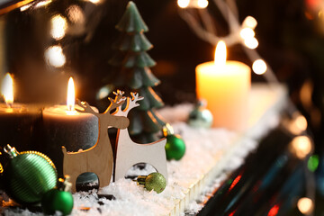 Wooden reindeers with Christmas decor and snow on piano keys, closeup