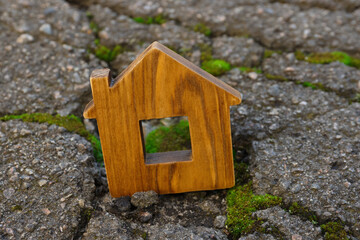 Obraz na płótnie Canvas Wooden house model in cracked asphalt. Earthquake disaster
