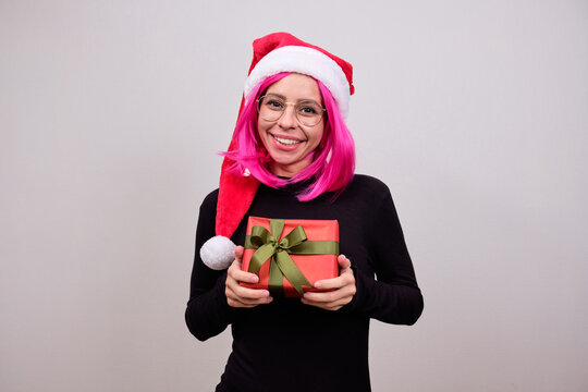 Woman with pink hair and a Christmas hat with a gift