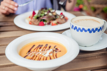 Close up of woman's hands eating salad at the cafe outside