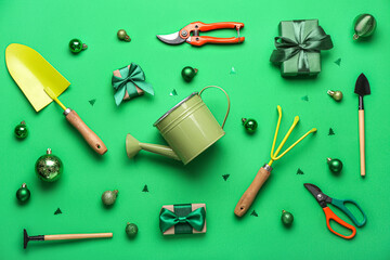 Gardening supplies with Christmas balls on green background