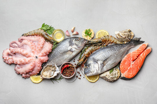 Flat lay composition with fresh raw dorado fish and different seafood on light grey table