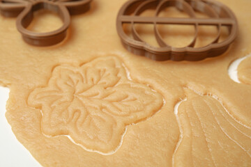 Cookie cutters and dough on white table, closeup