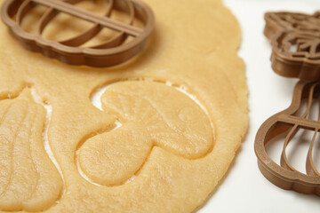 Cookie cutters and dough on white table, closeup