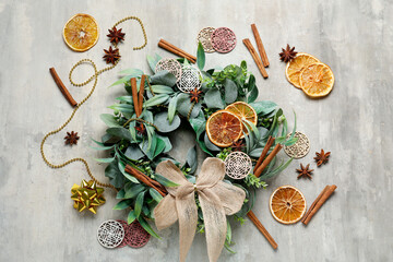 Stylish Christmas wreath with decorations, orange slices and cinnamon on grunge background