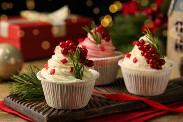 Delicious cupcakes and Christmas decorations on wooden table