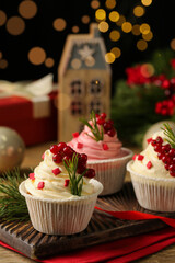 Delicious cupcakes and Christmas decorations on wooden table