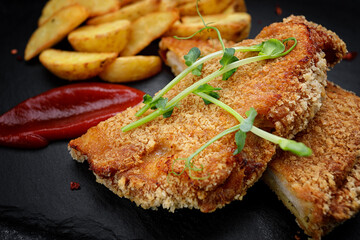 Pork schnitzel with potatoes, sauce and herbs
