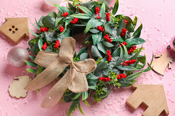 Composition with beautiful Christmas wreath, decorations and snow on pink background, closeup
