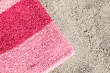 Fototapeta na wymiar Soft pink beach towel on sand, top view. Space for text