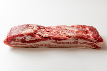 Whole pork belly on a white background