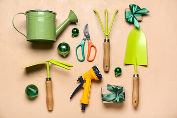 Gardening tools with Christmas decor and gifts on beige background