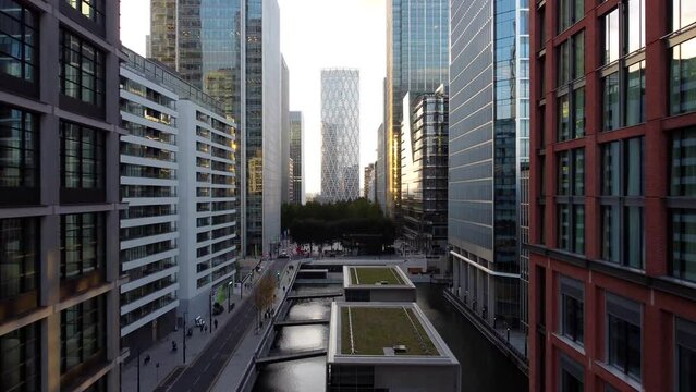 Drone shot flying between buildings in Canary Wharf at sunset, England