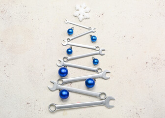 Christmas tree made of balls and wrenches on light background