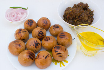 Litti with chicken, ghee and onion ring. It is popular in Bihar, Uttar Pradesh and Jharkhand. White background