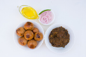 Litti with chicken, ghee and onion ring. It is popular in Bihar, Uttar Pradesh and Jharkhand. White background and top view