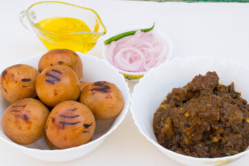 Litti with chicken, ghee and onion ring. It is popular in Bihar, Uttar Pradesh and Jharkhand. White background