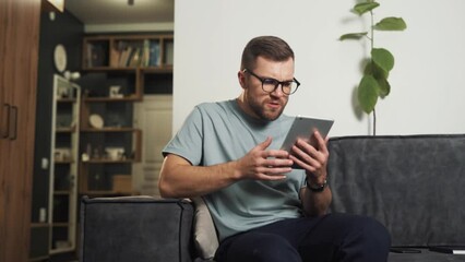 Shocked by what he saw in the tablet, the man begins to get angry and hit the tablet