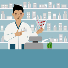Pharmacist at the pharmacy behind the counter. A male pharmacist holds medicines in his hand.
