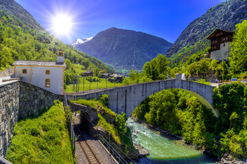 Fototapeta na wymiar Ancient stone bridge over the moutnain river in Swiss Alps, Stal