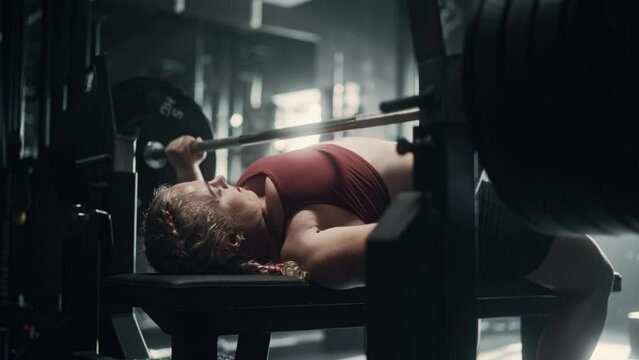 A Determined Female Powerlifter Finishing Her Workout Day in a Hardcore Gym. Powerful Athletic Woman Putting Heavy Barbell Down After Intense Training and Exercise. Slow Motion Shot