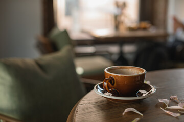 Stylish brown cup on wooden table. Cafe or restaurant concept. Copy space. 