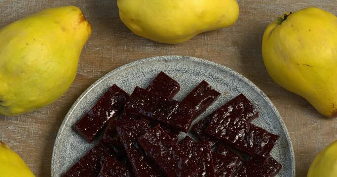 Membrillo - sweet, thick, sliceable firm paste made from quince fruit on a plate. Table spin.