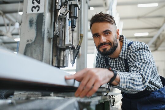 Worker in uniform working on machine in PVC shop indoor
