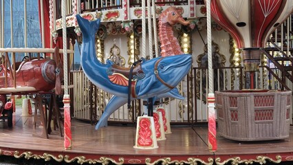 The merry-go-round at the amusement park is spinning and sparkling with lights. 