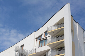 Exterior of beautiful building with balconies against blue sky, space for text