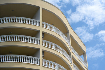 Obraz premium Exterior of beautiful building with balconies against blue sky, low angle view