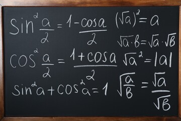 Different mathematical formulas written with chalk on blackboard