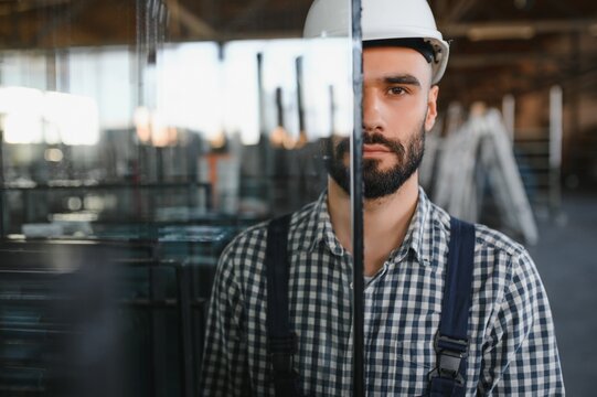 the glazier takes a piece of mirror off the table. Glass factory, manufacture