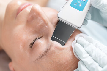 Close-up detail beautician doctor making skin care peeling cleansing procedure by ultrasonic...