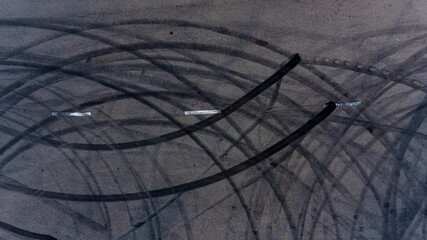 Top view tire tracks texture and background. Asphalt texture with line and tire marks. Automobile automotive tire skid mark on race track. Abstract texture car drift tire skid mark. - obrazy, fototapety, plakaty