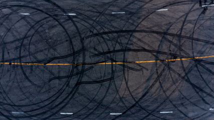 Top view tire tracks texture and background. Asphalt texture with line and tire marks. Automobile automotive tire skid mark on race track. Abstract texture car drift tire skid mark. © Darunrat