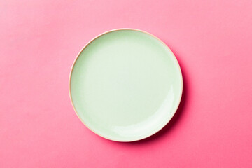 Top view of isolated of colored background empty round green plate for food. Empty dish with space...