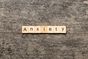 ANXIETY word written on wood block. ANXIETY text on table, concept